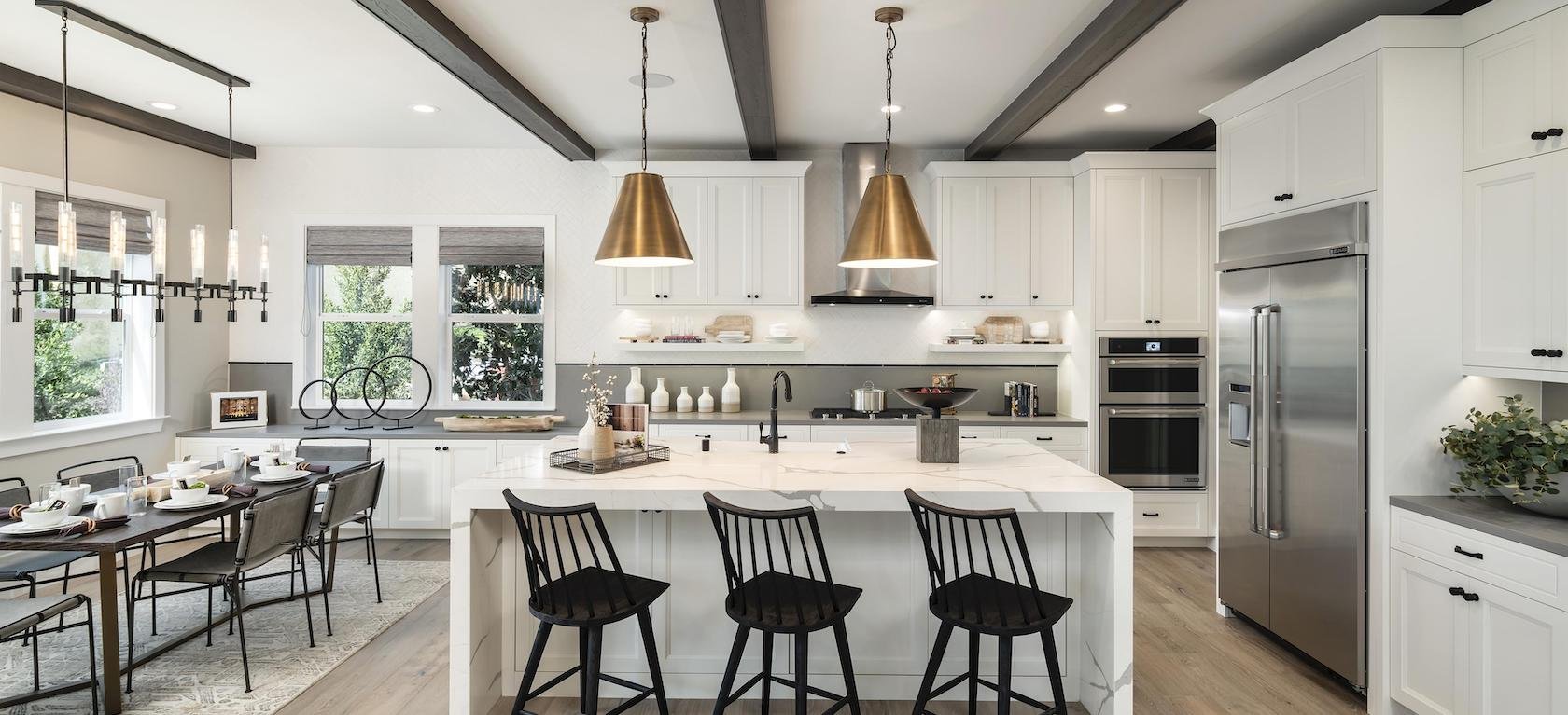 Beautiful finished kitchen with marble island and brass pendant lighting